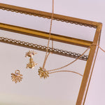 Moonstone & White Sapphire Sunburst Necklace 9k Gold in mirror jewellery tray along with the flat back and earring charm