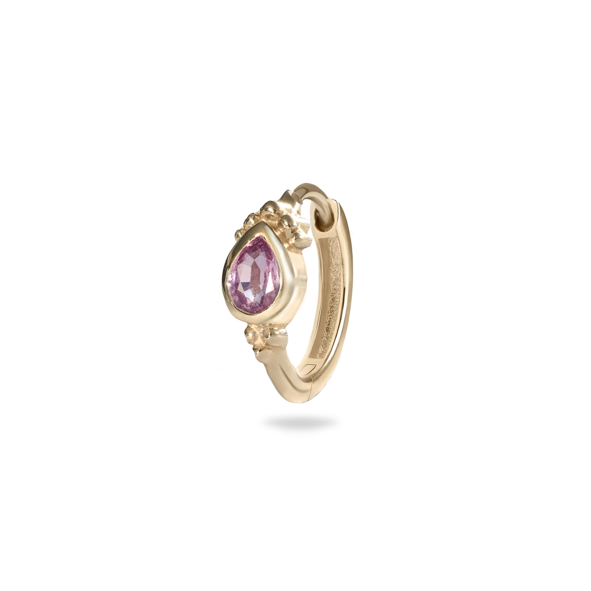 Gold hoop earring with a pink gemstone on a white background