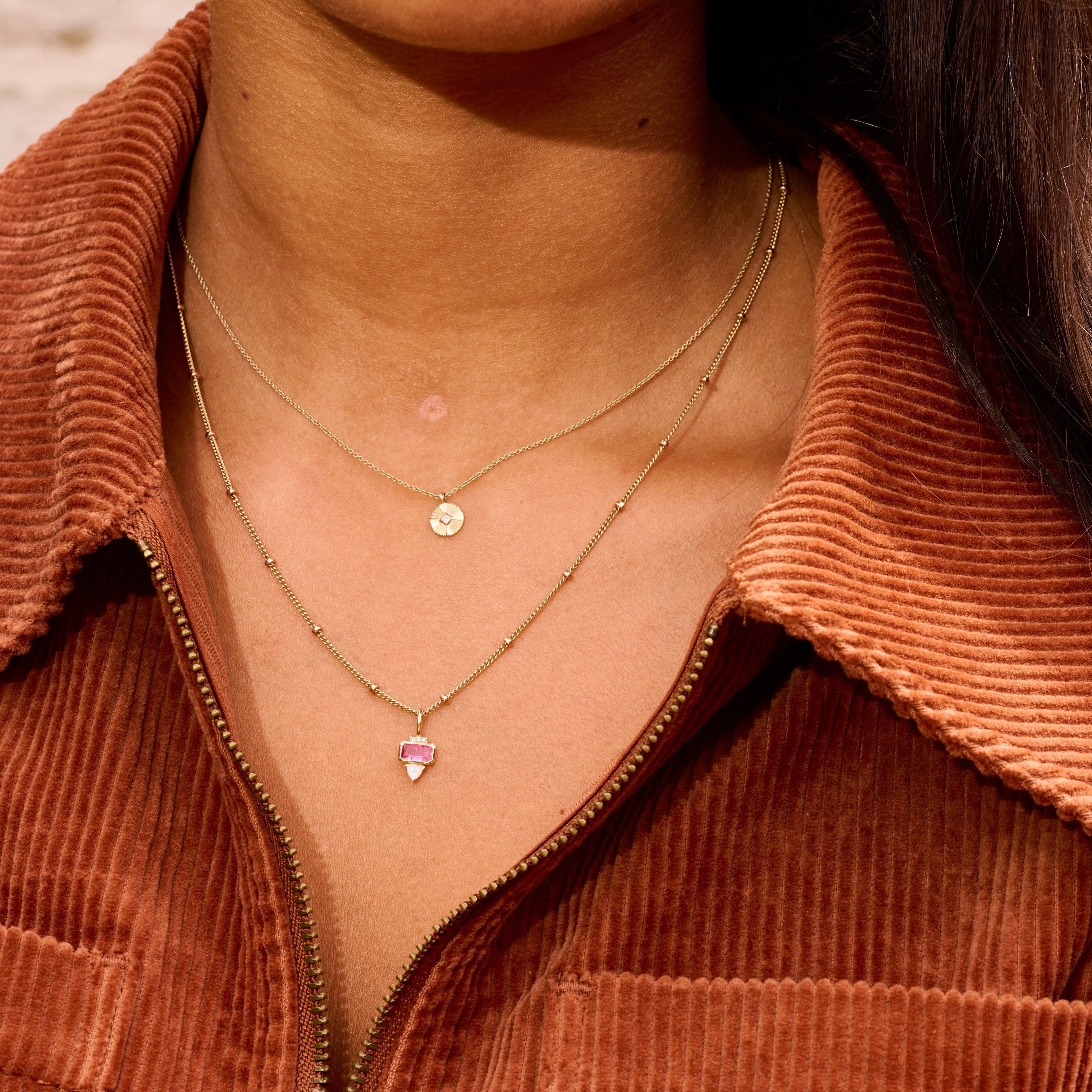 model wearing solid gold necklace one of them the Pink Tourmaline, Diamond & Moonstone Pendant 9k Gold