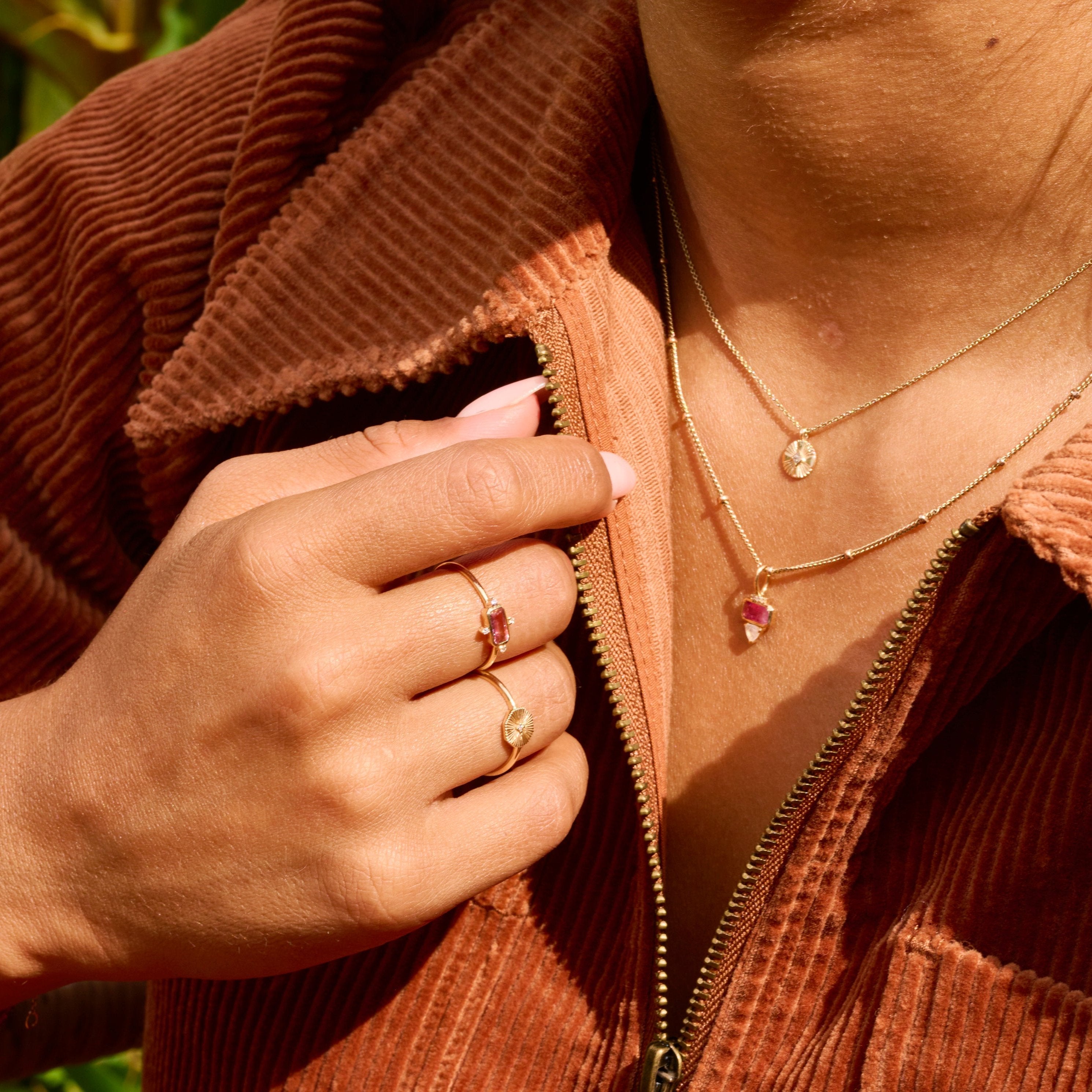 model wearing matching rings and necklaces including the Pink Tourmaline & Diamond Ring 9k Gold 