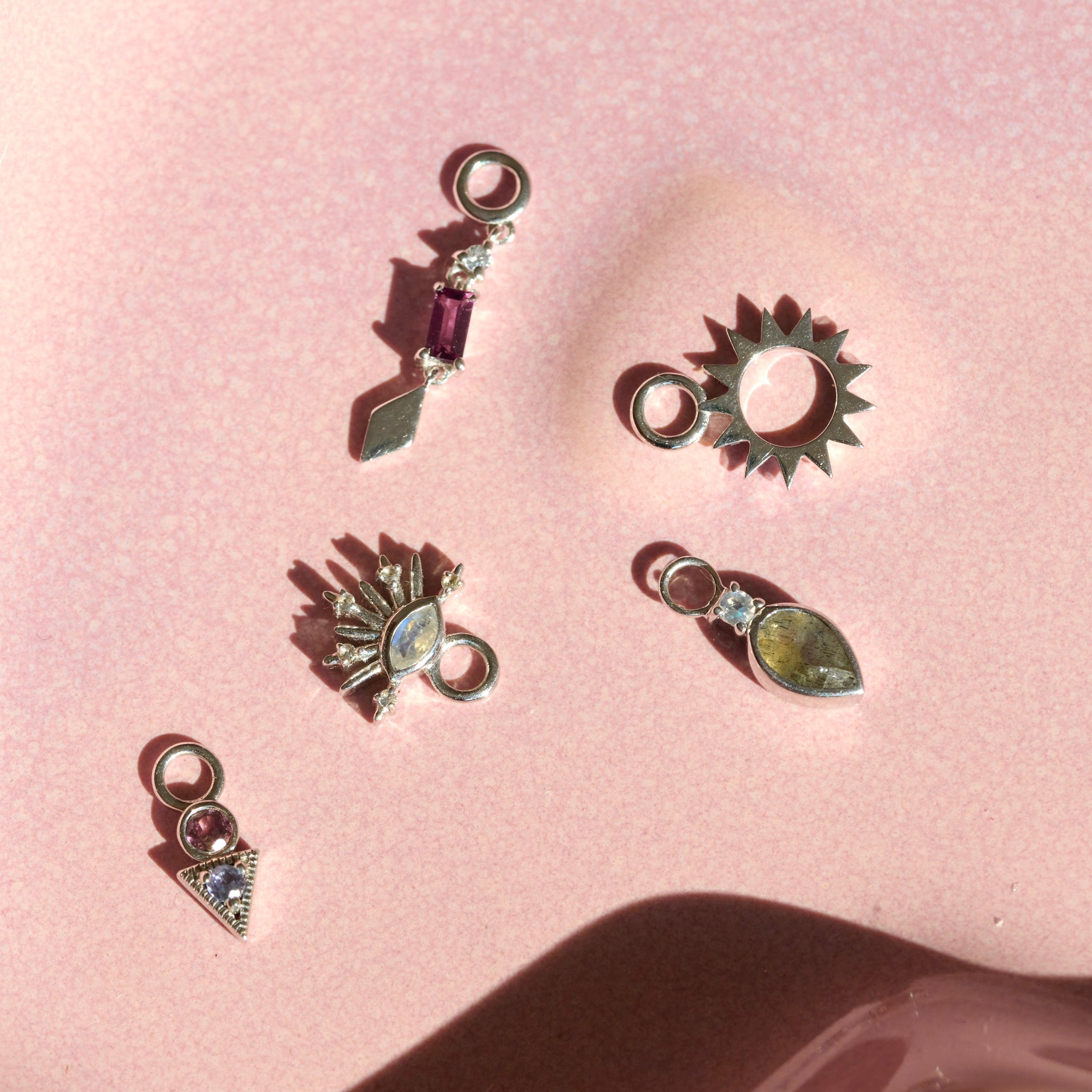 sterling silver earring charms displayed on hard surface including the Rhodolite Garnet & White Sapphire Earring Charm Sterling Silver