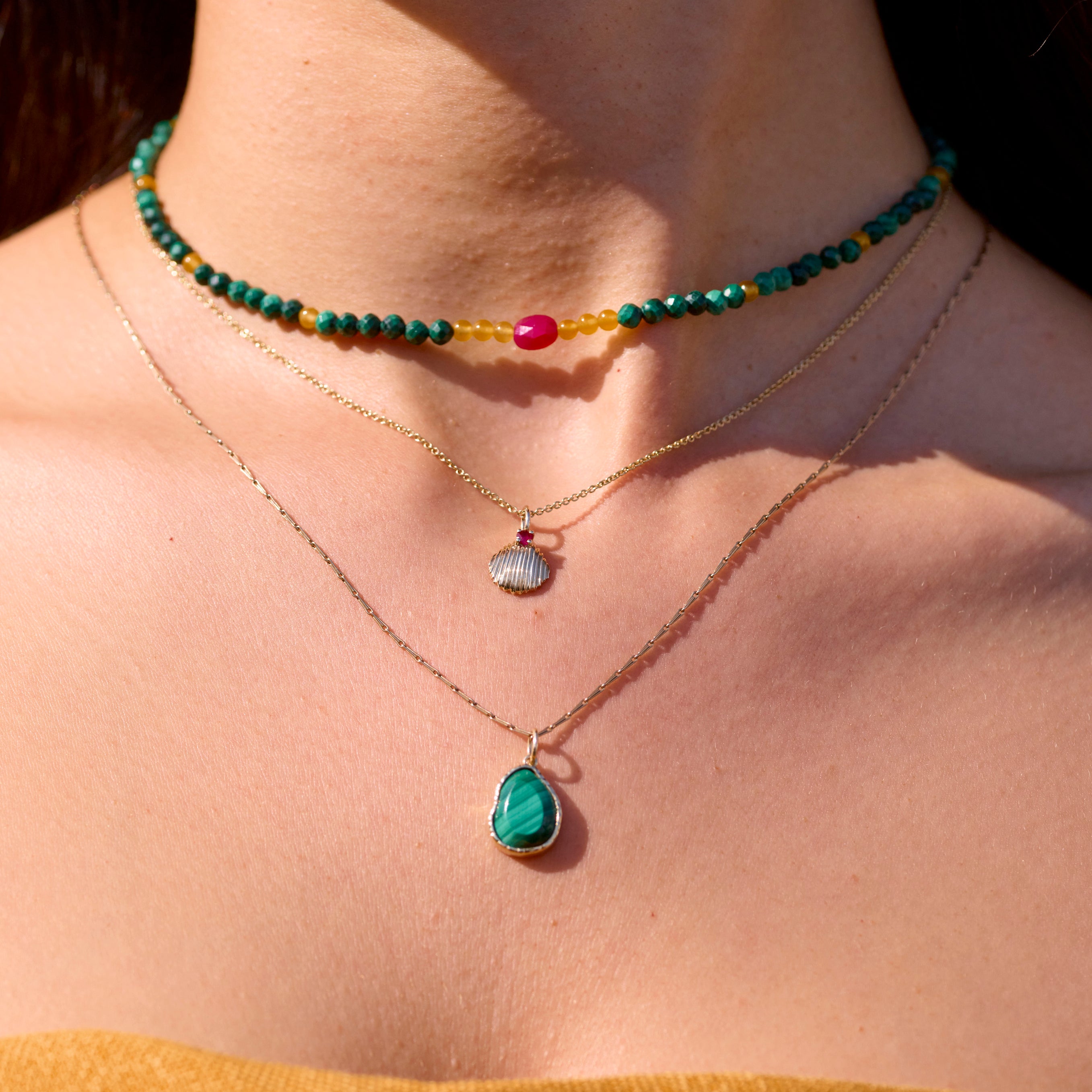 gold necklaces with beaded necklace on model