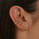 model wearing suspender earrings in 14k gold vermeil along with ear cuffs including the White Sapphire Celestial Ear Cuff 14k Gold Vermeil