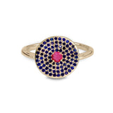 Gold ring with blue and pink gemstones on a white background