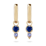 Gold earrings with blue and purple gemstones on a white background