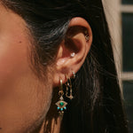 model wearing solid gold earrings and charms including the Snake Flat Back Earring 14k Gold