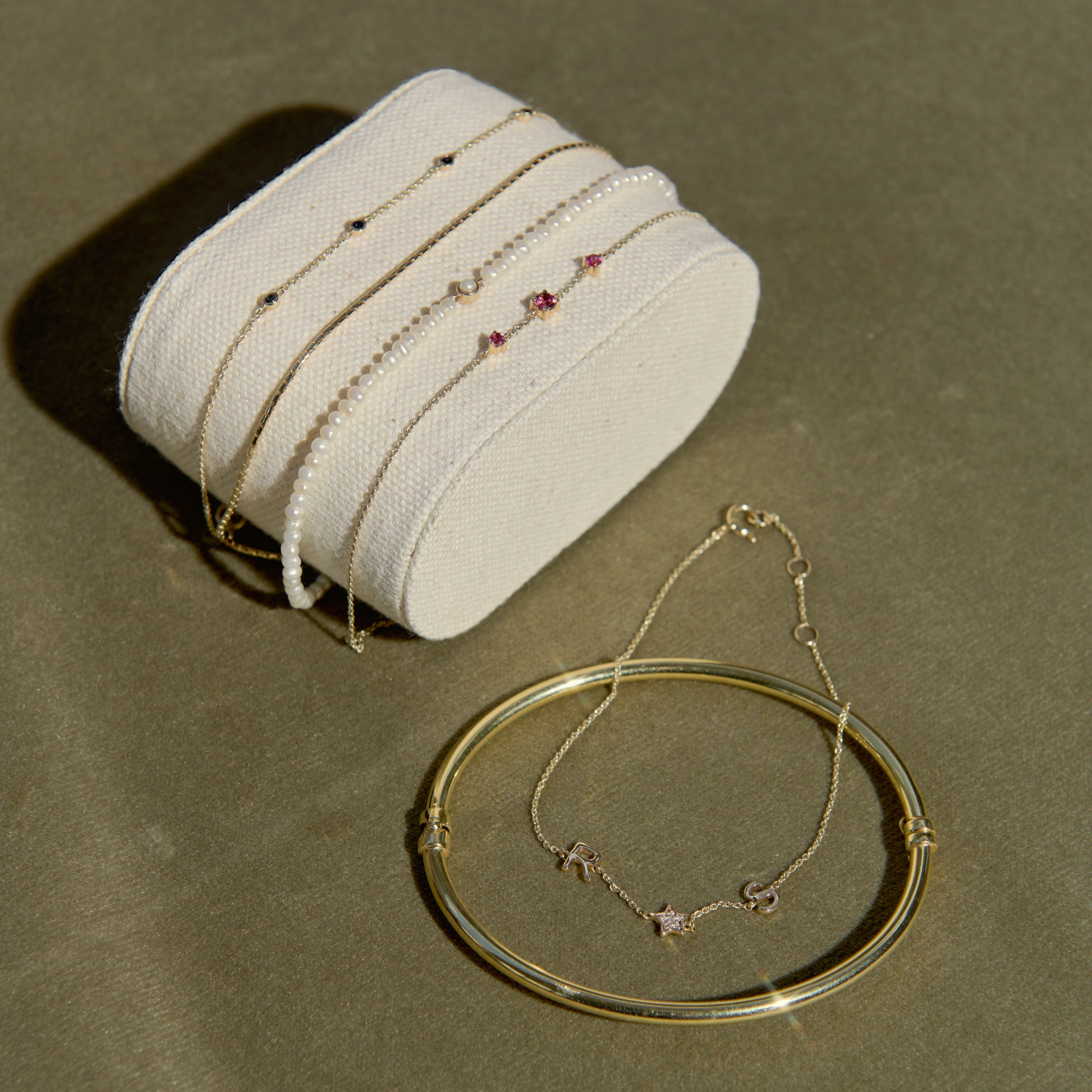 solid gold bracelets on a green background