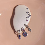 Pair of earrings with gemstones on a white stone surface