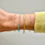 model wrist showing the Station Bead Chain Bracelet 9k Gold along with other solid gold bracelets including the twisted gold bracelet