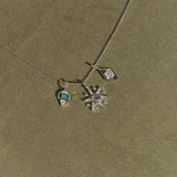 Necklace with star-shaped pendant and green gemstone on a green background