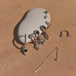 Silver jewelry set on a beige surface