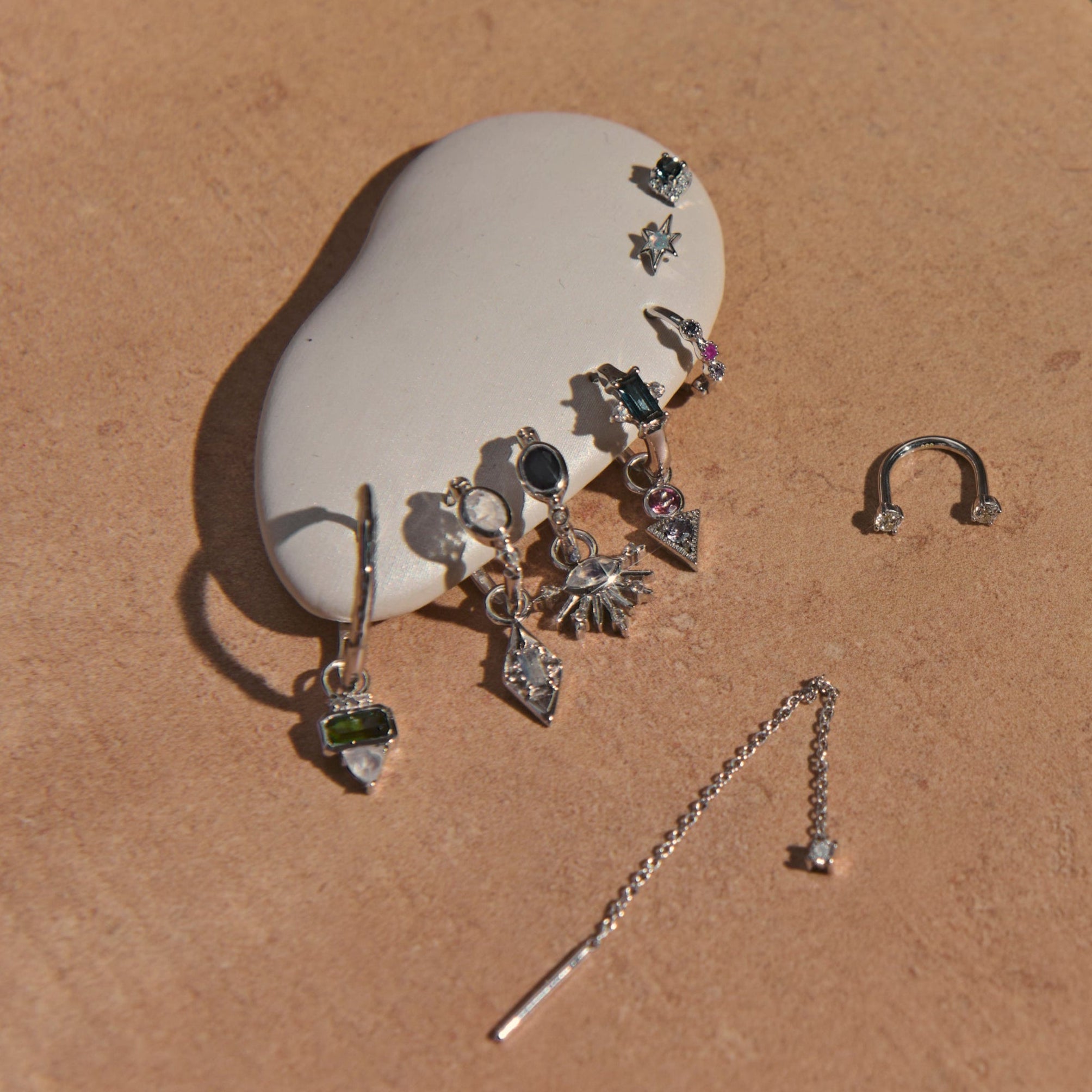 Silver jewelry set on a beige surface