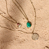 Summer gold pendants on sand