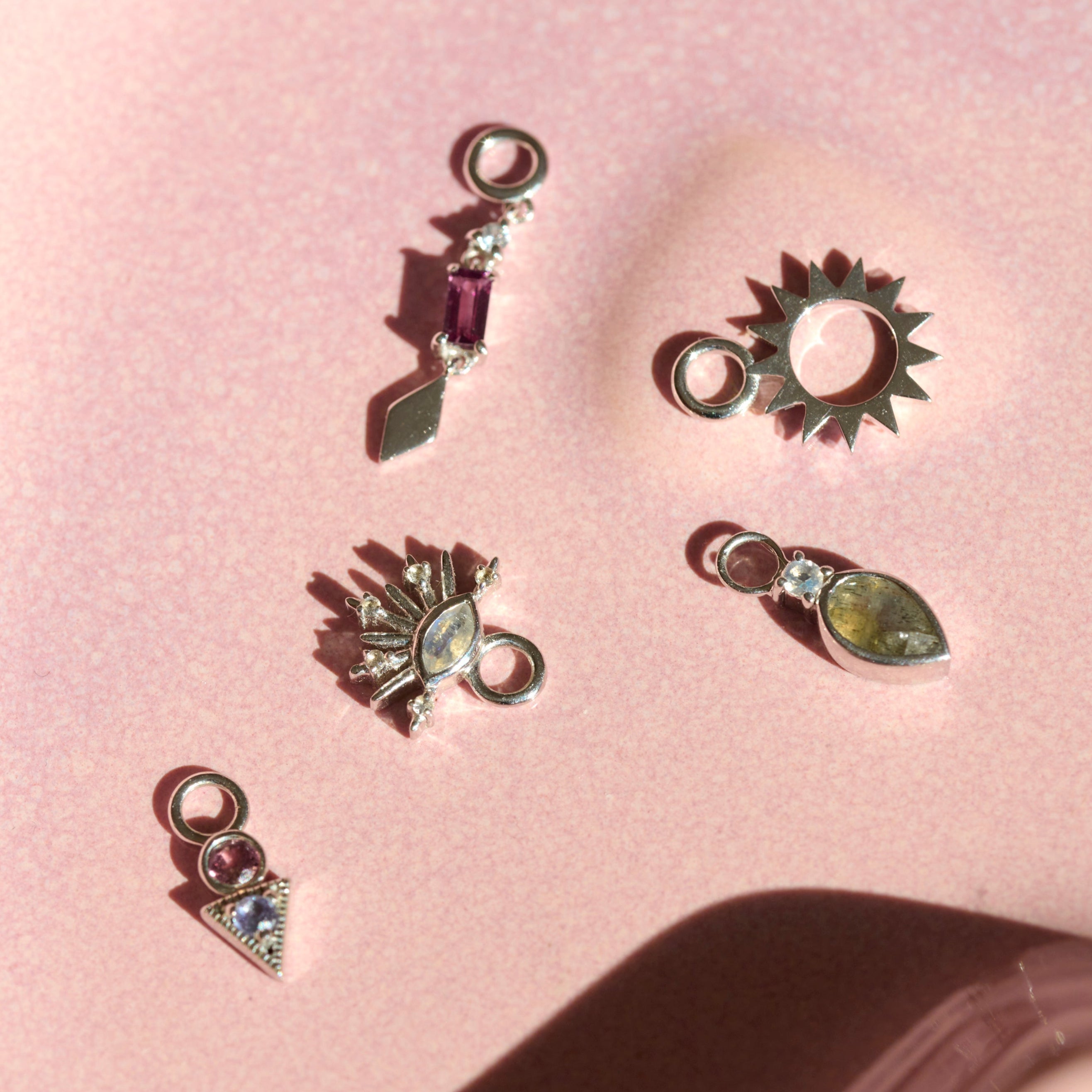 sterling silver earring charms displayed on hard surface including the Sunburst Silhouette Earring Charm Sterling Silver