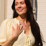 model wearing solid gold necklaces including the Sunburst Silhouette Necklace 9k Gold
