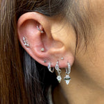 close up of silver earring in ear
