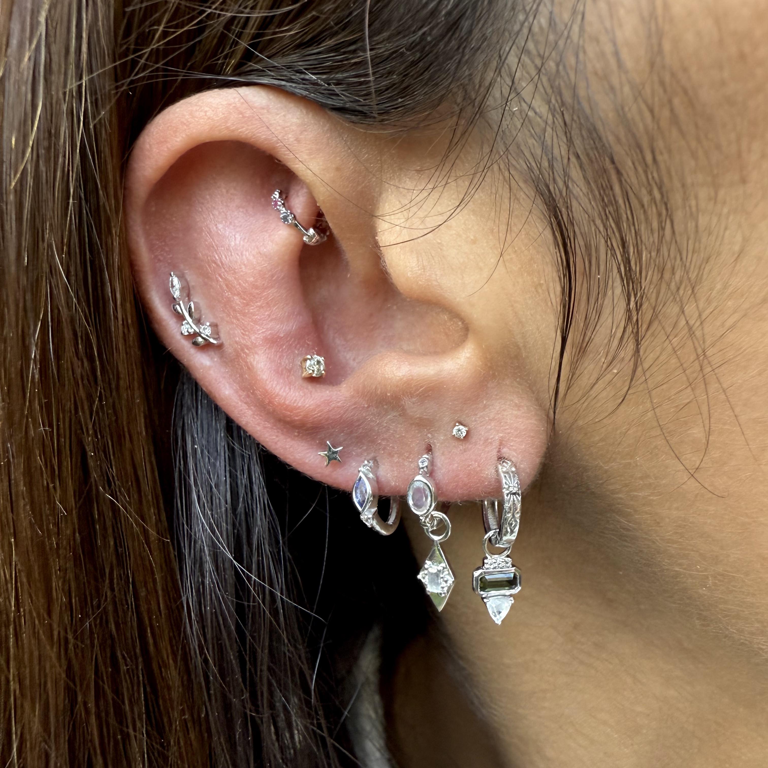 close up of silver earring in ear