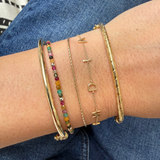 model wrist wearing solid gold bracelets including the Twisted Bangle 9k Gold