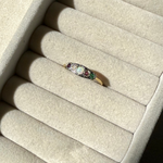 Ring with gemstones on a beige jewelry display