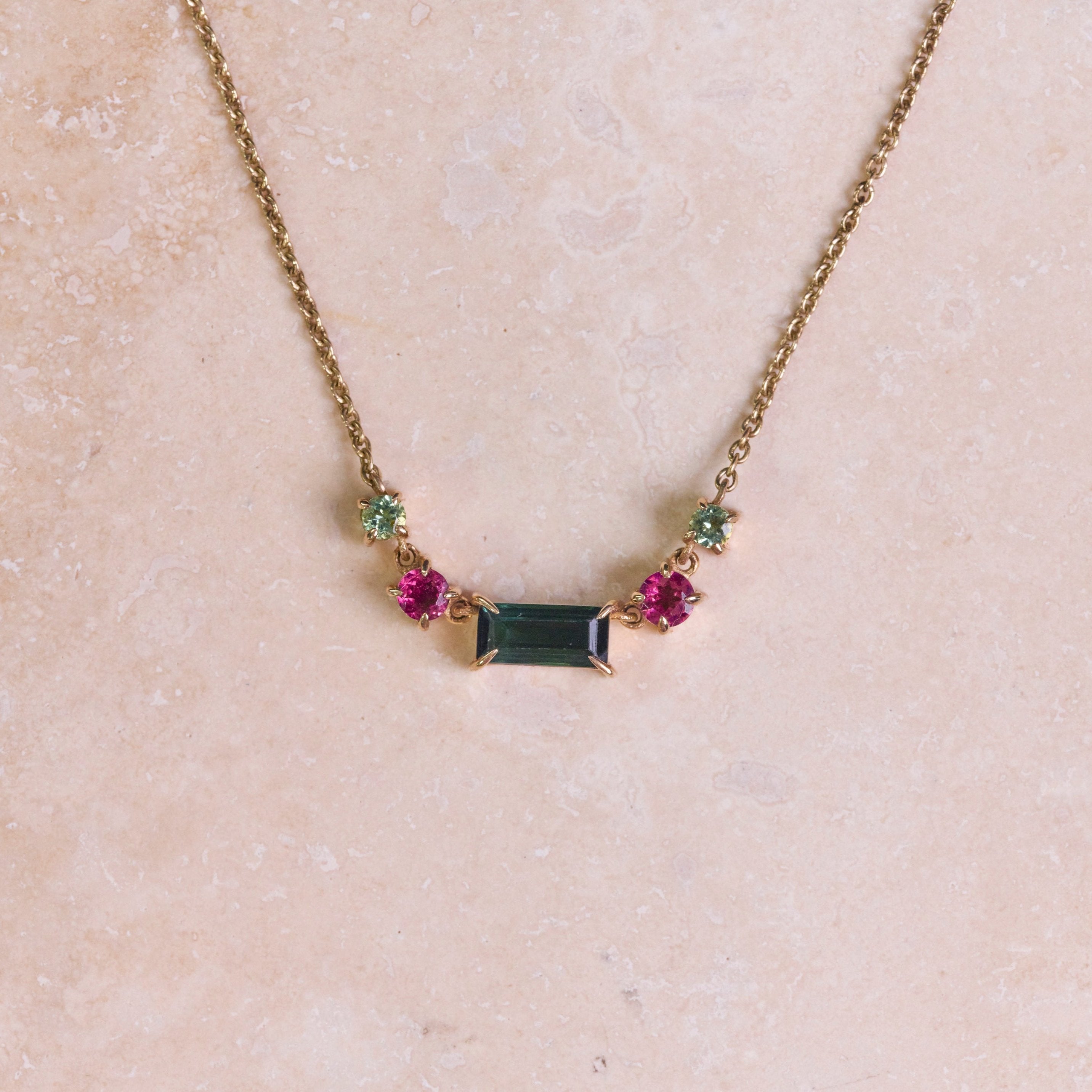 Watermelon Tourmaline Necklace 9k Gold on hard surface