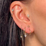 solid gold ear stack including the Wave Huggie Hoop Earring 9k Gold