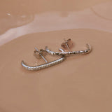 close up of the White Sapphire Pave Suspender Earring Sterling Silver and hammered suspender earring