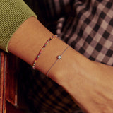 model wearing White Sapphire Solitaire Bracelet Sterling Silver along with beaded bracelet