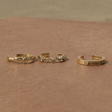 White Sapphire Starburst Ear Cuff 14k Gold Vermeil displayed on stone surface along with other 14k gold vermeil ear cuffs