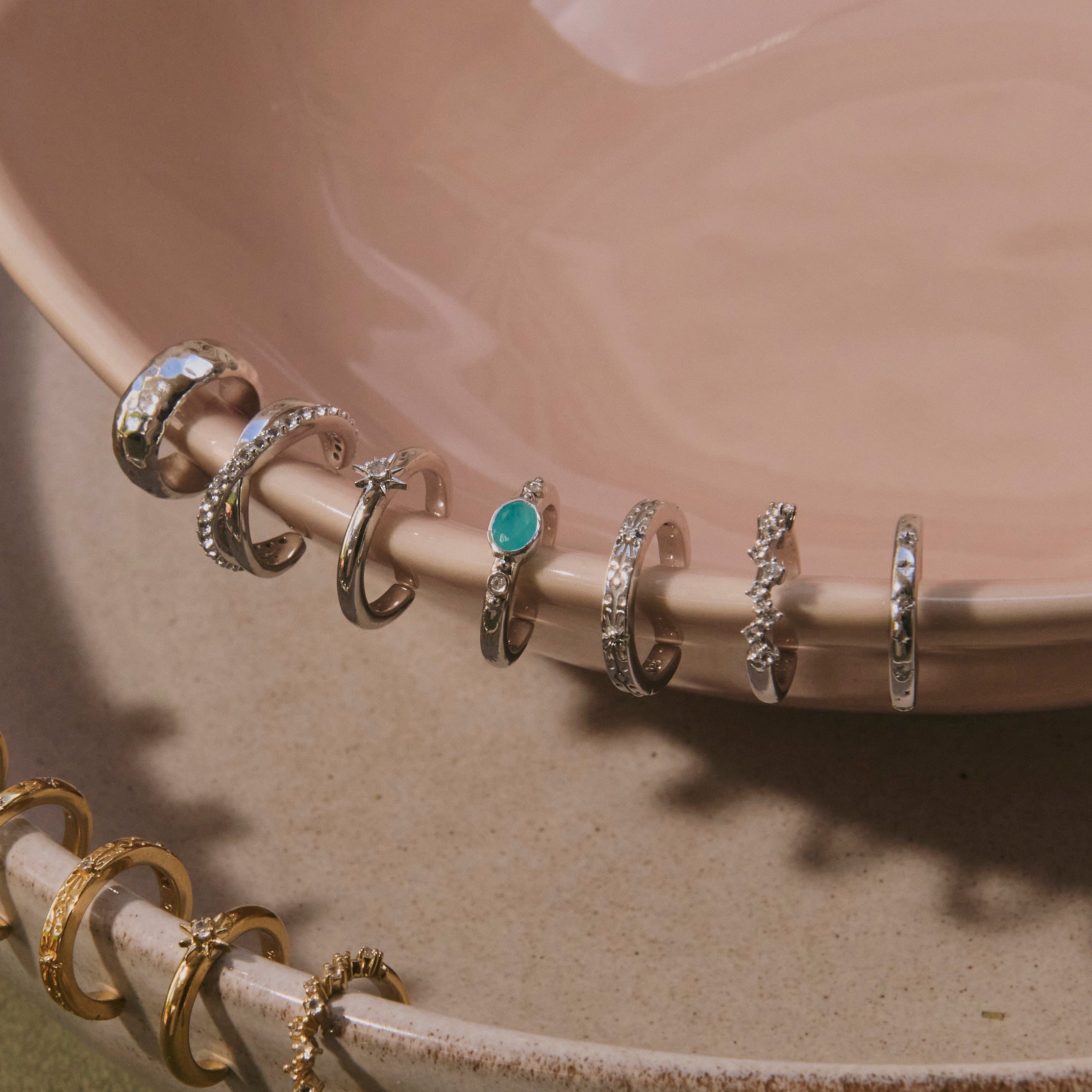sterling silver ear cuffs displayed on porcelain dish including the White Sapphire Starburst Ear Cuff Sterling Silver
