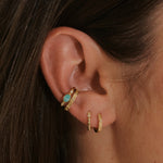 close up of model ear wearing gold pieces including the White Sapphire Starburst Ear Cuff 14k Gold Vermeil

