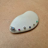 Set of jewelry earrings on a white stone against a beige background