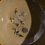 Set of small silver jewelry pieces on a textured surface