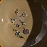 Set of small silver jewelry pieces on a textured surface