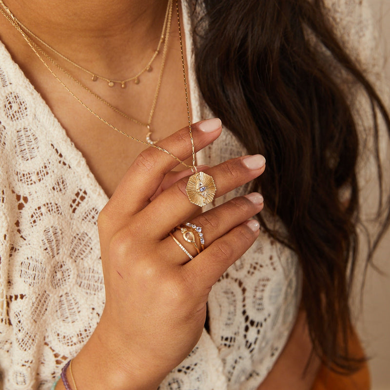 model wearing the Moonstone & Diamond Tear Drop Ring 9k Gold along with other solid gold pieces