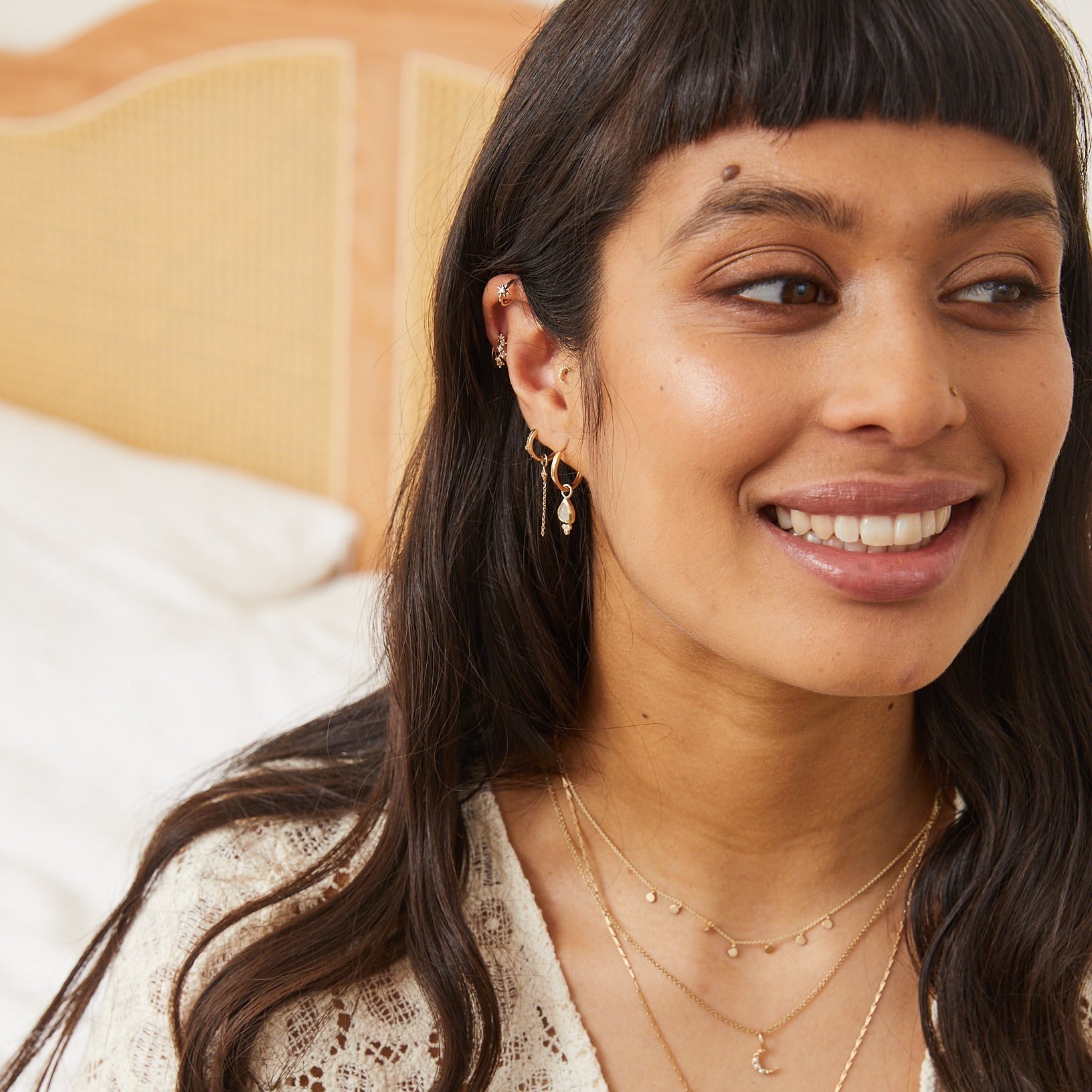 model wearing gold jewellery including the Diamond Starburst Huggie Hoop Earring 9k Gold