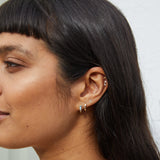 model wearing gold earring stack including the Labradorite & Diamond Huggie Hoop Earring 9k Gold