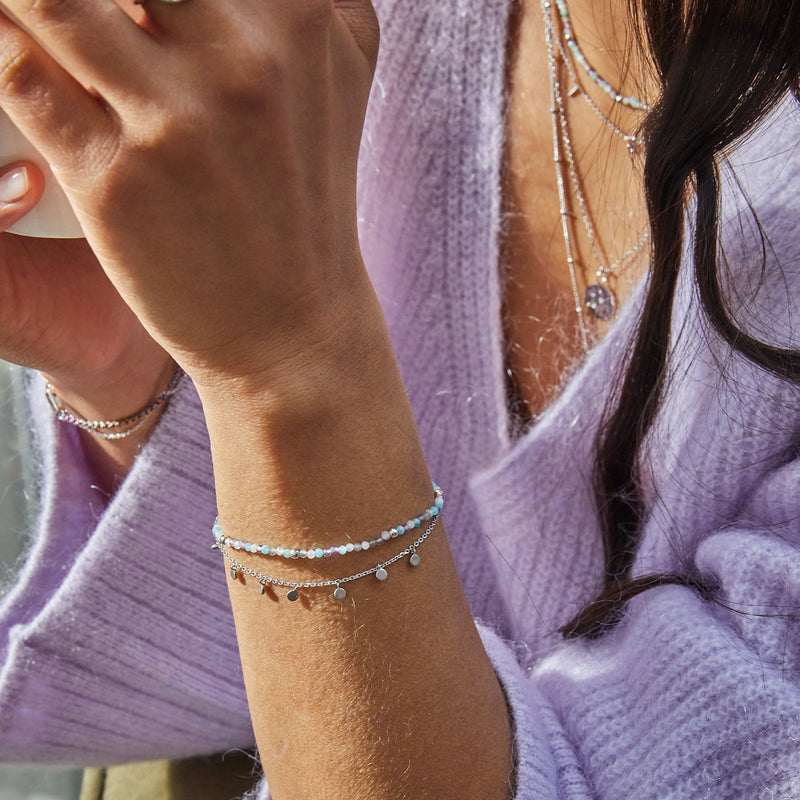 model wearing Mini Coin Bracelet Sterling Silver and a bead bracelet