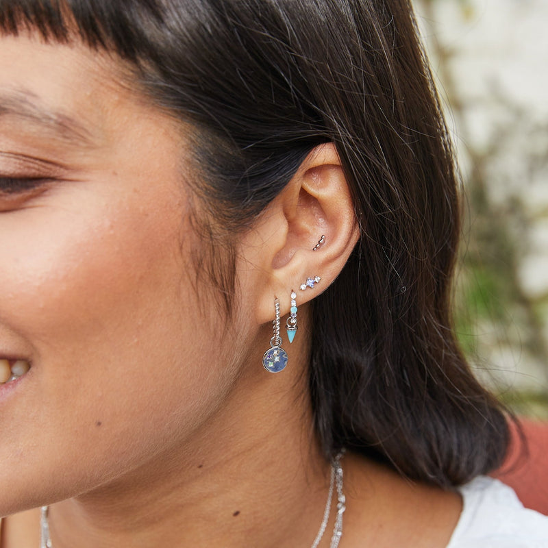 model ear wearing silver earrings including the Amazonite, Tanzanite & Moonstone Huggie Hoop Earring Sterling Silver