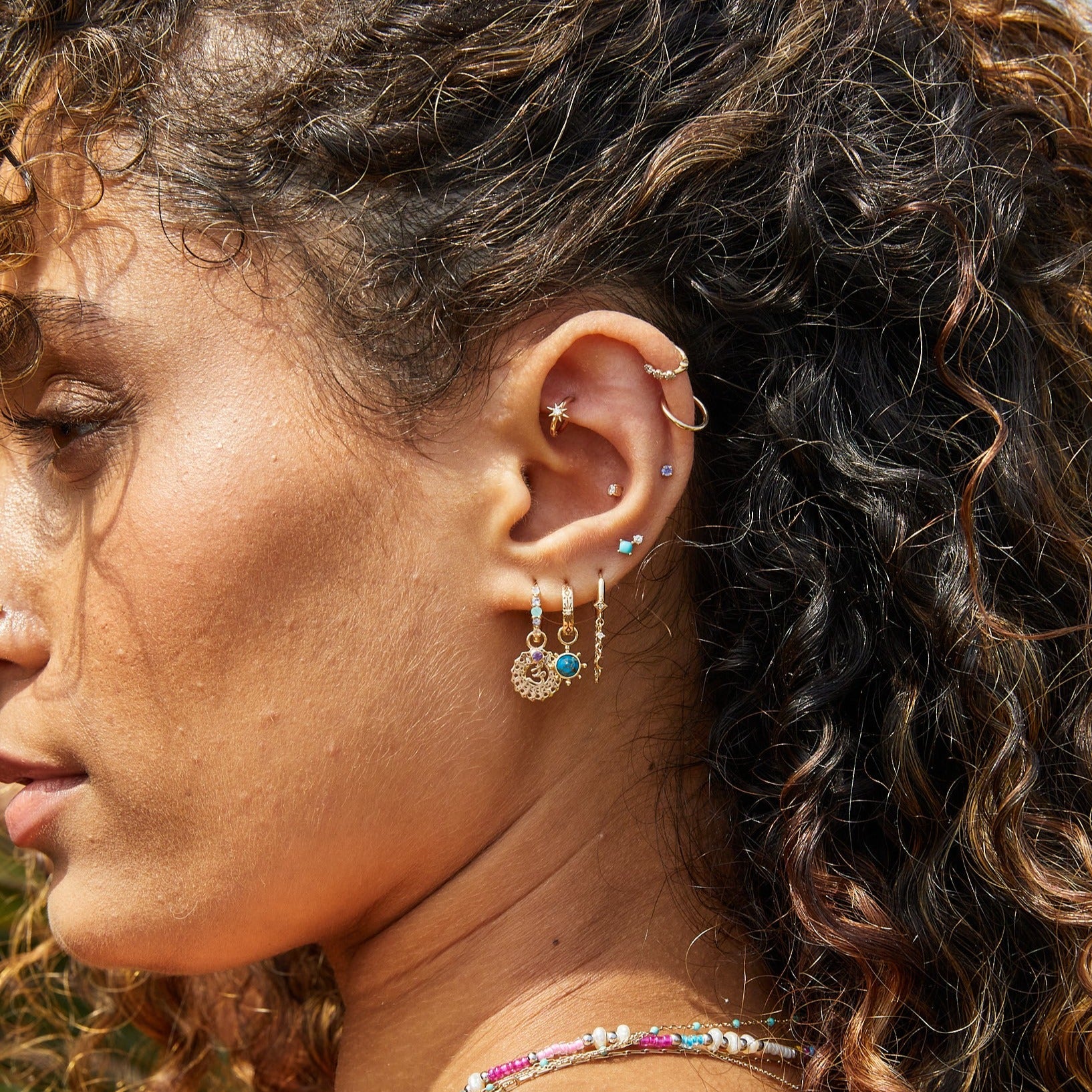 model wearing solid gold earrings including the Copper Turquoise Earring Charm 9k Gold