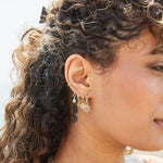 model wearing solid gold earring stack including the Peridot Baguette Hoop Earrings 9k Gold