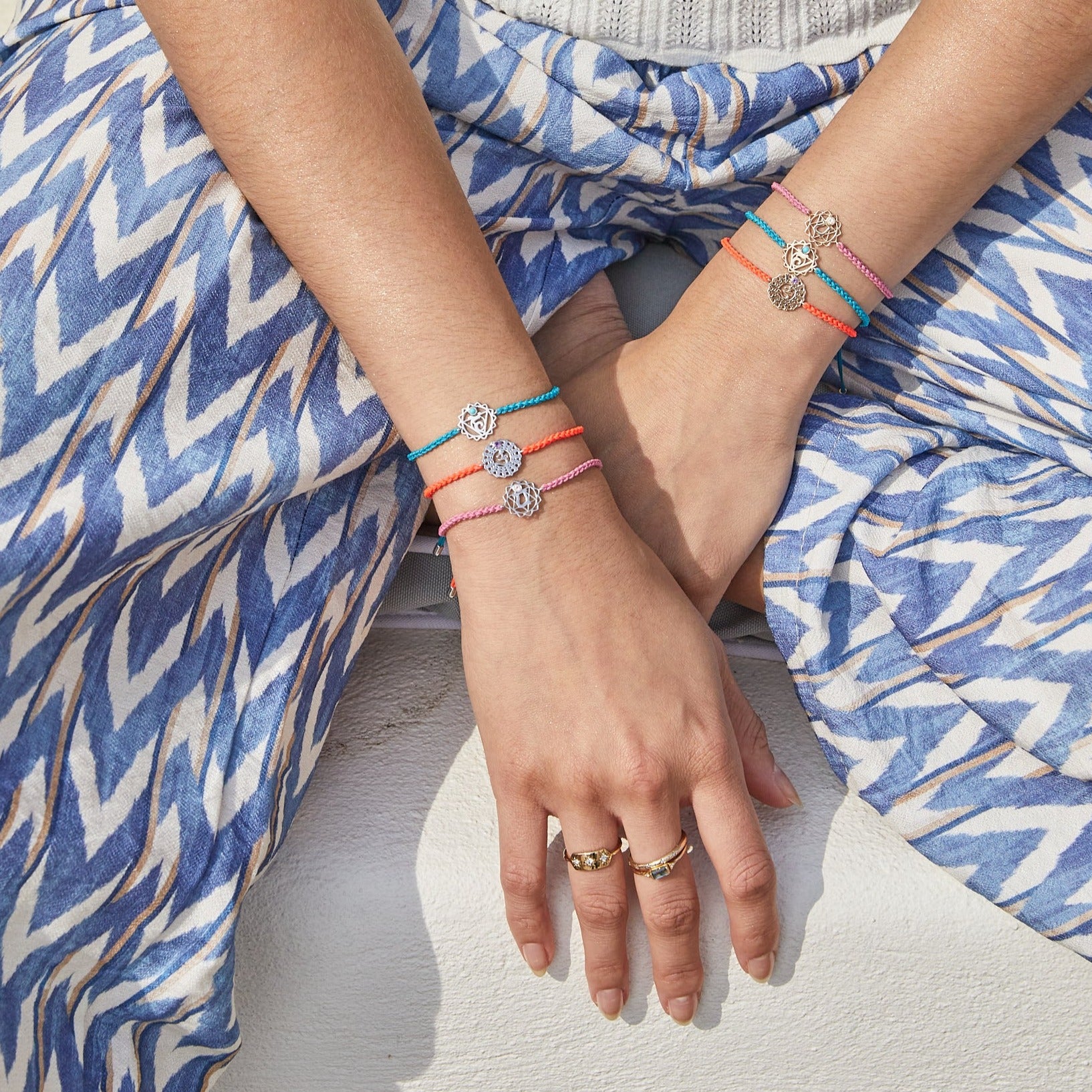 sterling silver and solid gold chakra bracelets on model wrist including the Crown Chakra Bracelet sterling silver