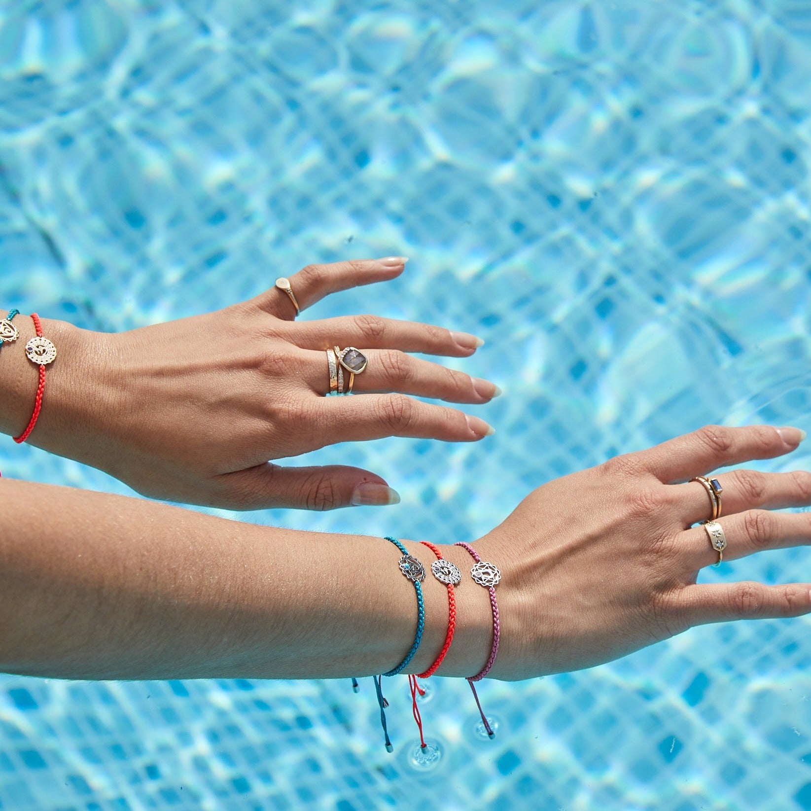 model wearing solid gold and sterling silver chakra bracelets including the Heart Chakra Bracelet Sterling Silver