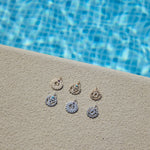 gold pendant displayed by the pool including the Heart Chakra Pendant 9k Gold