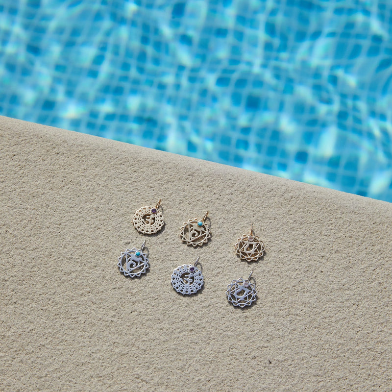 gold pendant displayed by the pool including the Crown Chakra Pendant 9k Gold