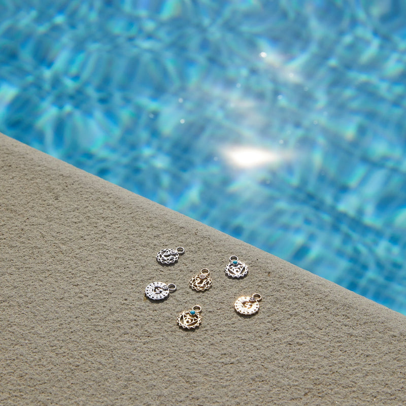 chakra charms in solid gold and sterling silver by the pool