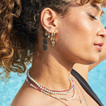 model by the pool wearing solid gold pieces including the Aztec Turquoise Earring Charm 9k Gold