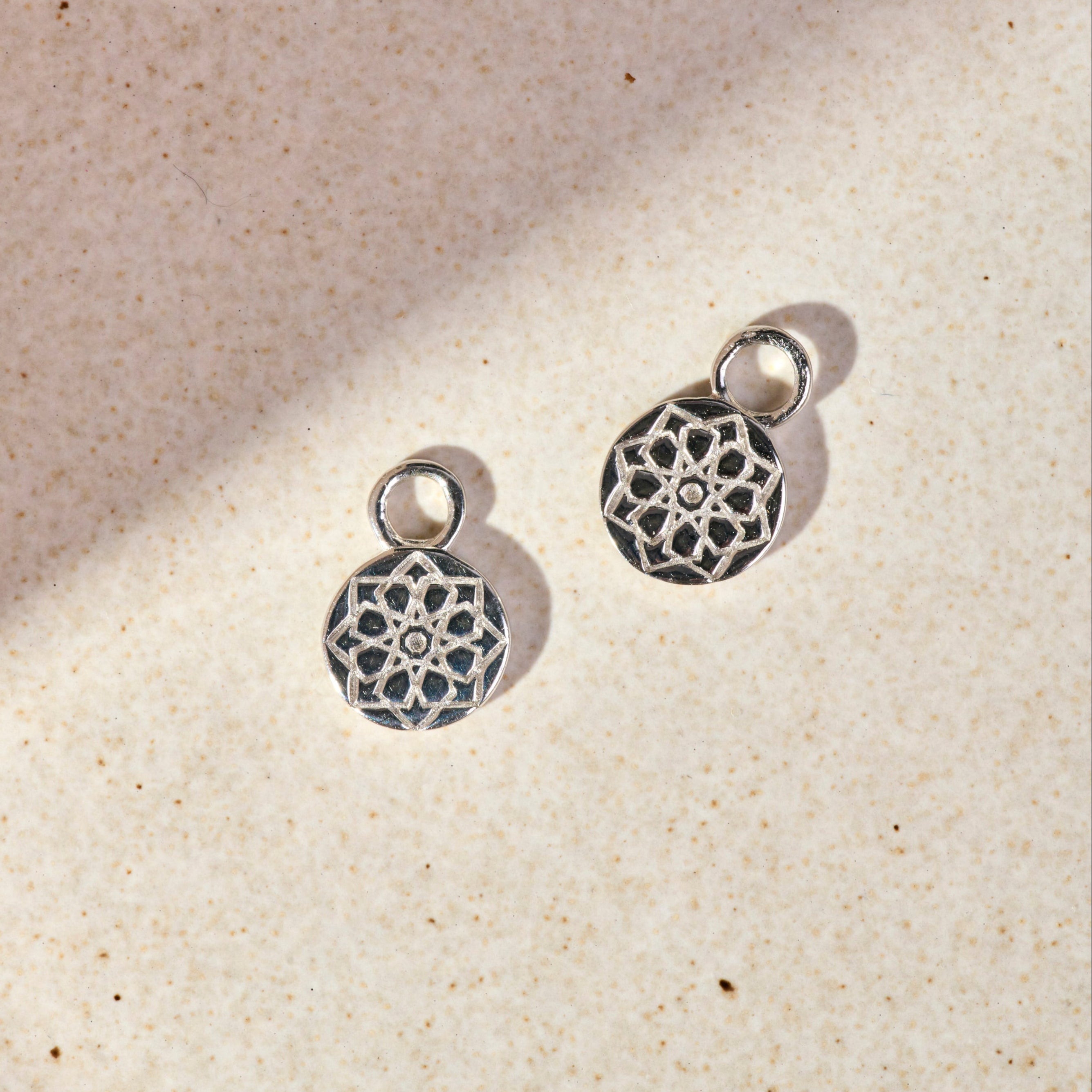 Zohreh Coin Earring Charm Sterling Silver on hard surface