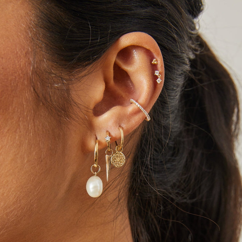 close up of solid gold earring stack including the Baroque Pearl Earring Charm 9k Gold