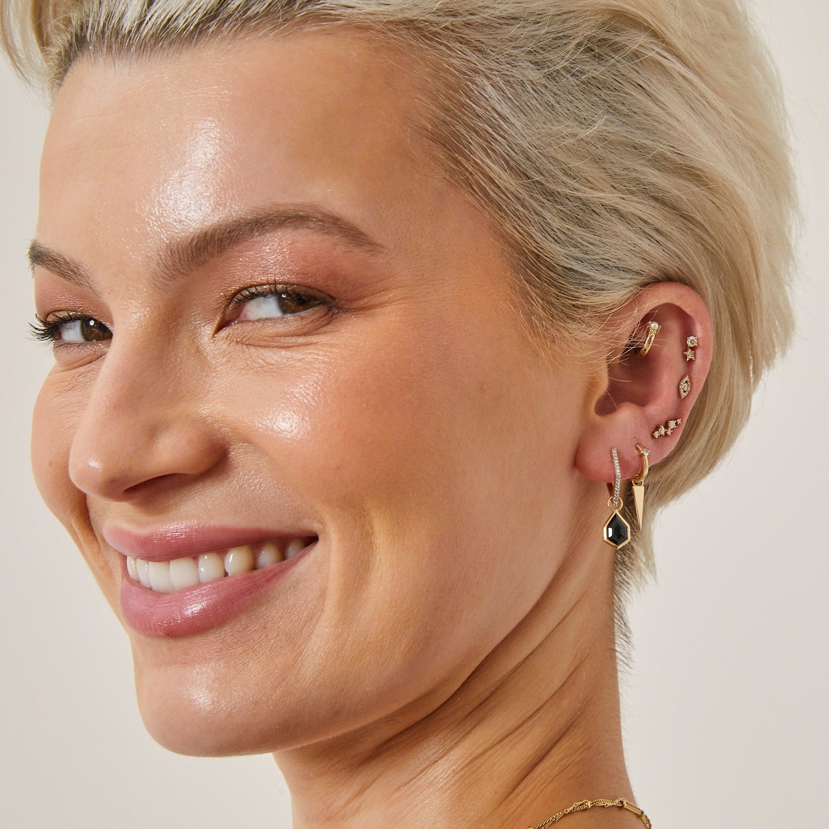 model earing ear stack in solid gold including the Spike Hoop Earrings 9k Gold