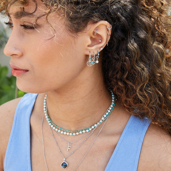 model wearing solid metal jewellery including the Copper Turquoise & White Sapphire Huggie Hoop Earring Sterling Silver